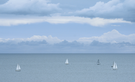 clouds over water with sailboats